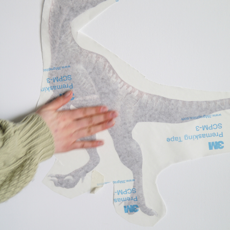 Main appliquant l'autocollant sur le mur